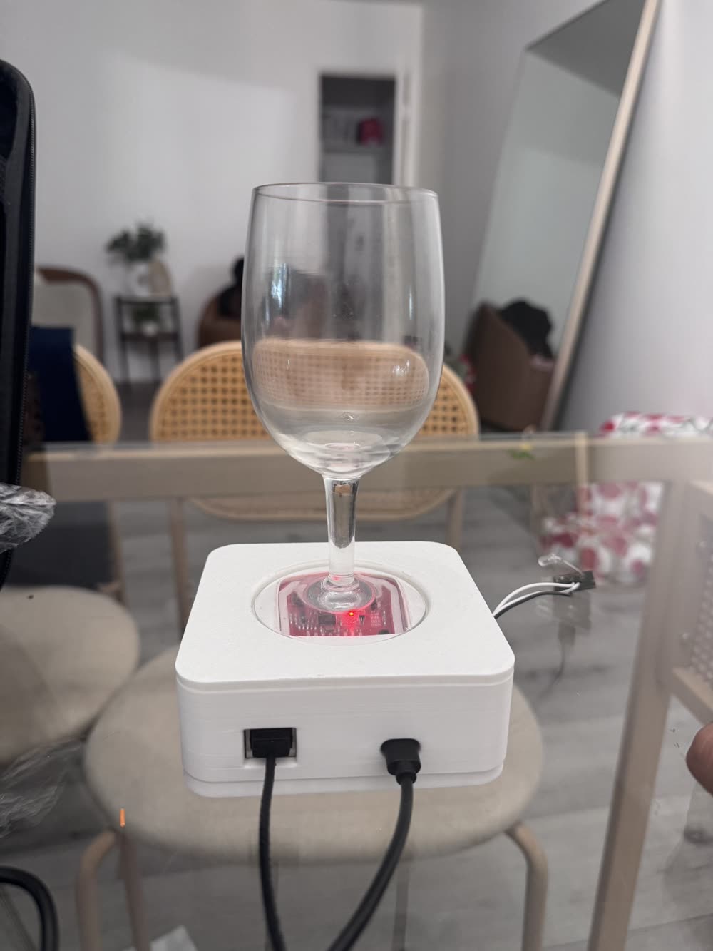 Wine glass seated in a circular pocket on the lid of a white 3D-printed hub, with the red NFC reader board visible beneath the glass